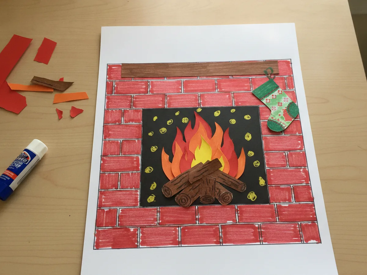 Finished paper fireplace with red brick front, brown logs, glowing red orange and yellow flames, and a small paper stocking hanging from the brown mantel
