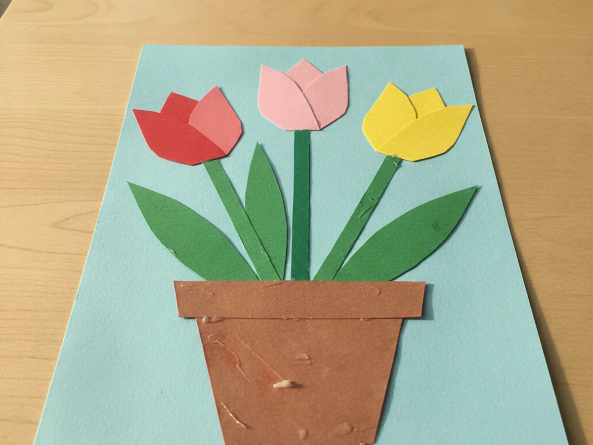 Finished paper tulip craft with red, pink, and yellow paper tulips in a brown paper flower pot on a light blue background